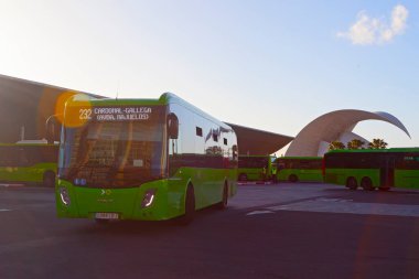 TENERIFE, SPAIN - February 16, 2022: Main bus station of the green buses operated by Titsa, located near the port of Santa Cruz de Tenerife in front of the famous auditorium of Tenerife. clipart