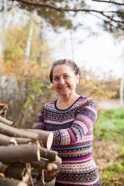 Sonbahar manzarasının arka planında süveter giymiş güzel yaşlı kadın portresi. 