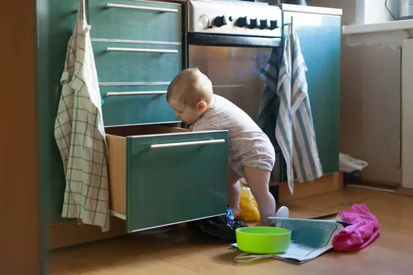 Маленькая Годовалая Девочка Выбрасывает Вещи Кухонных Шкафов Лицензионные Стоковые Фото