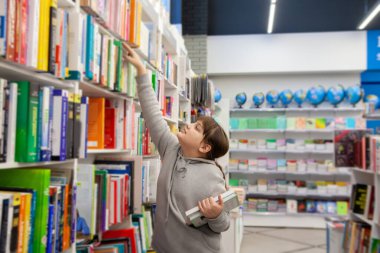 Portrait of   eleven - year - old teenage girl in   bookstore . 