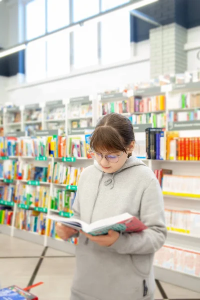 Teenage Girl Gray Hoodie Choosing Books Store — стоковое фото