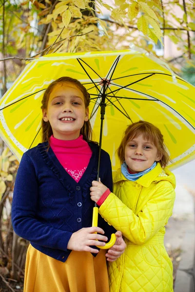 Dos Chicas Años Abrazándose Bajo Paraguas Amarillo Otoño —  Fotos de Stock