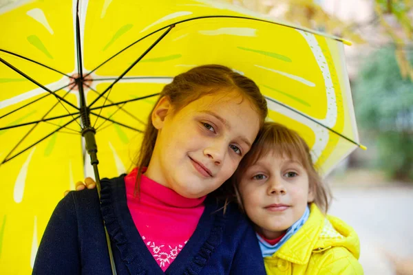Dos Chicas Años Abrazándose Bajo Paraguas Amarillo Otoño —  Fotos de Stock