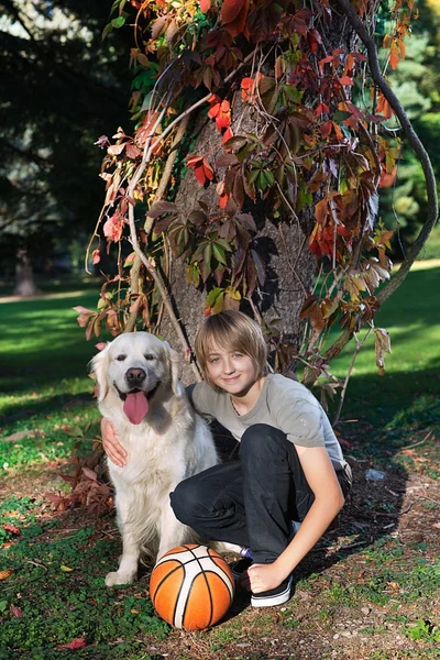 Jongen met zijn hond in het park — Stockfoto