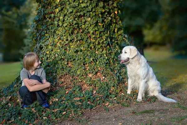 Pojken med sin hund i parken — Stockfoto