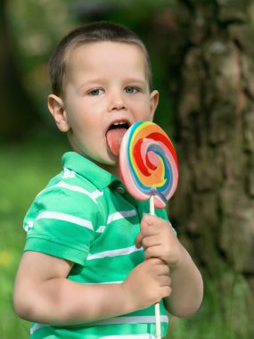 küçük çocuk bir lolipop yalıyor