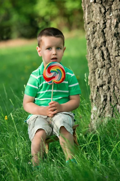 Piccolo ragazzo leccare un lecca-lecca — Foto Stock