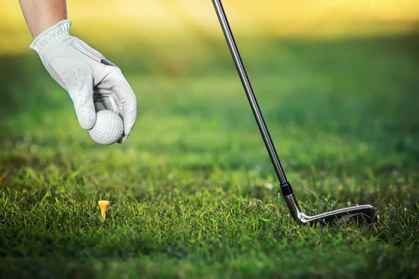 Boule de golf à main avec tee-shirt sur le parcours, gros plan — Photo