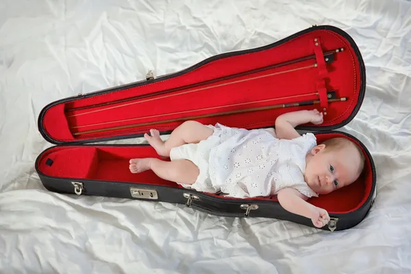 Petite fille allongée dans une caisse de violon — Photo