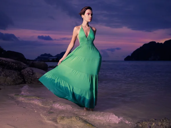 Dame in grünem Kleid am Strand — Stockfoto