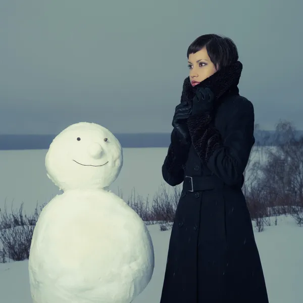 Femme avec bonhomme de neige — Photo