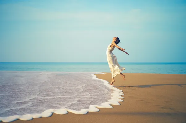 Ung dam som hoppar på stranden — Stockfoto