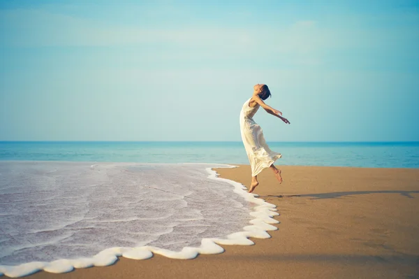 Giovane signora saltando sulla spiaggia Fotografia Stock