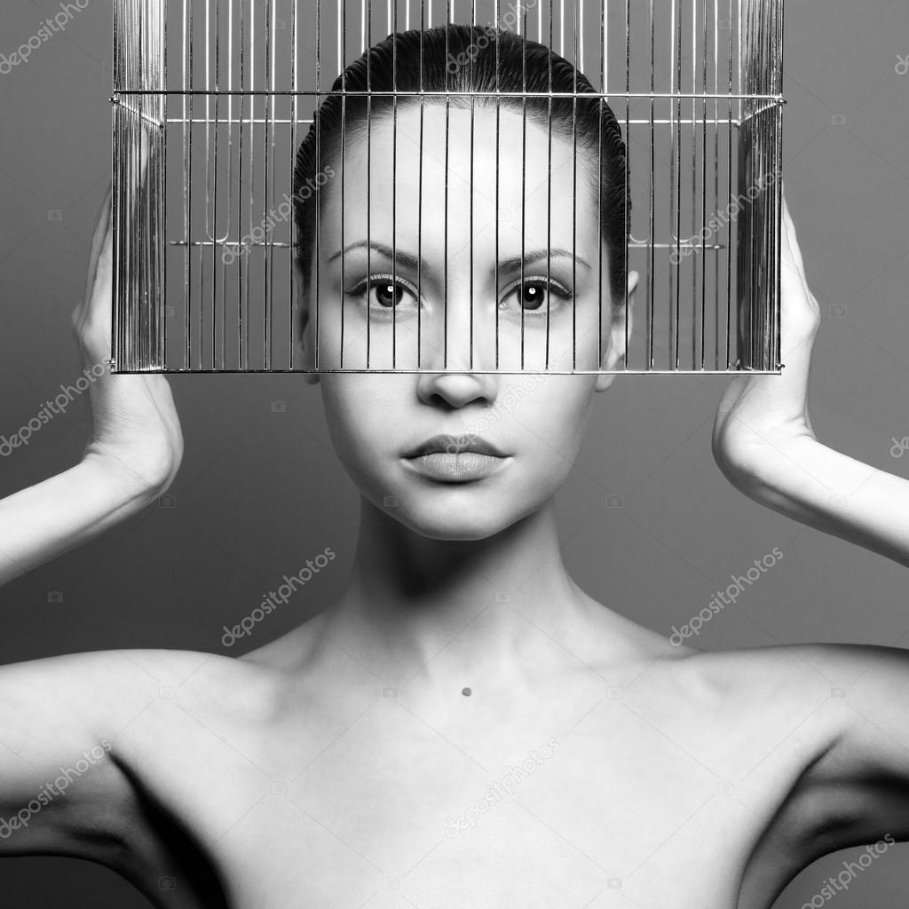 Surrealistic portrait of young lady with cage