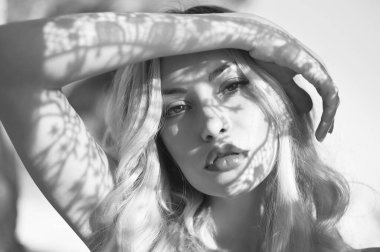 The girl walks along the sea. Beautiful sexy woman with gorgeous hair is relaxing on the beach. Portrait of a model with a pattern on her face. 