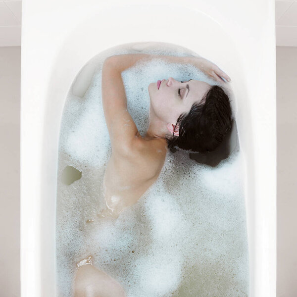 Portrait of young beautiful woman. Sexy lady with magnificent eyes in bathroom. 