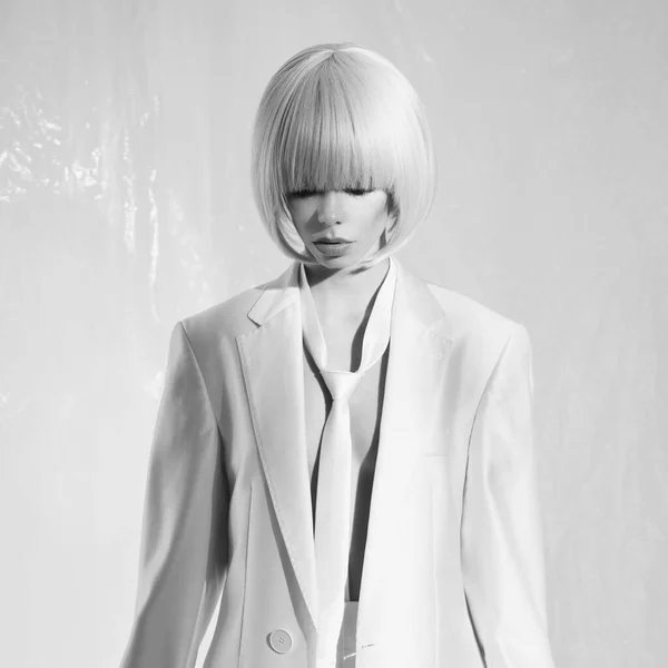 Studio fashion photo of young elegant woman in white men's jacket and tie. Fashion and style. Perfect makeup
