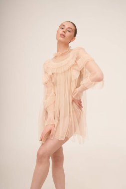 young beautiful girl posing in a romantic dress. Sunlight. Sexy model in transparent dress.