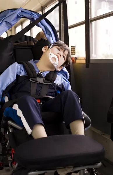 Niño discapacitado sentado en silla de ruedas en el autobús escolar —  Fotos de Stock