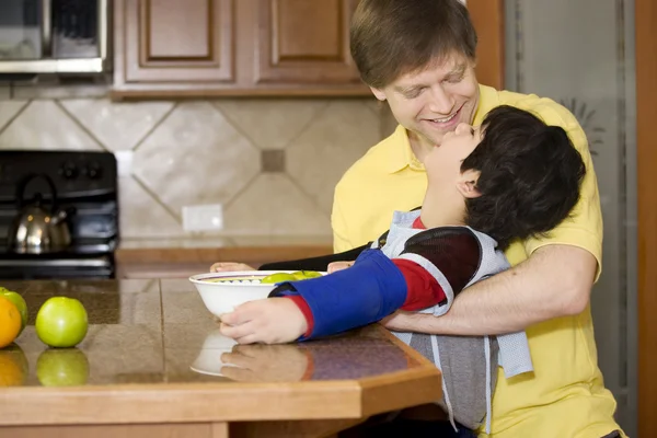 Отец помогает сыну-инвалиду с работой на кухне — стоковое фото