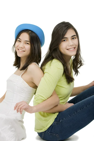 Two sisters sitting together, isolated on white — Stock Photo, Image