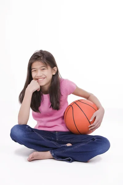 Niña asiática de diez años sosteniendo baloncesto, aislada en blanco —  Fotos de Stock