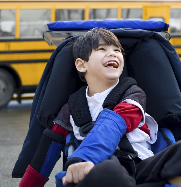 Inaktiverat fem-årig pojke i rullstol, som skolbuss — Stockfoto