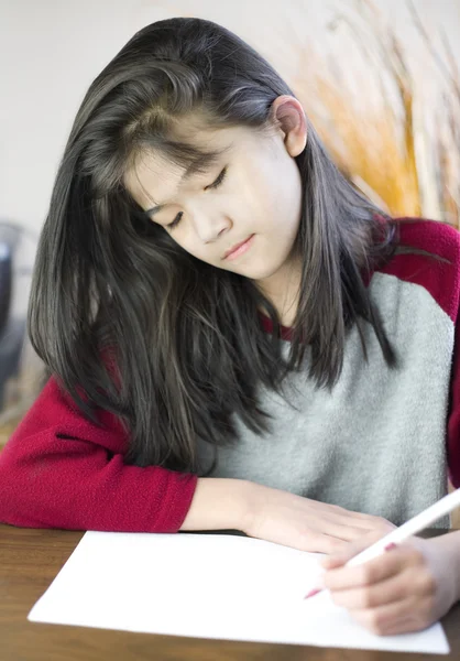 Десятирічна дівчинка пише або малює на папері — стокове фото