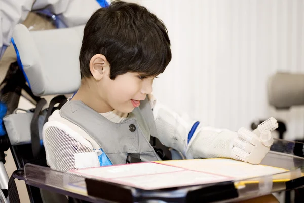 Niño discapacitado de cinco años estudiando en silla de ruedas —  Fotos de Stock