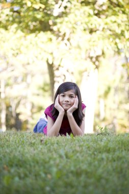 çimlerde uzanmış küçük kız