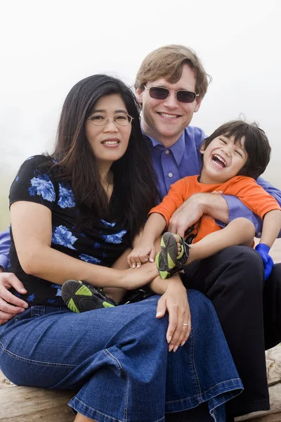 Mutiracial rodina sedí na pláži — Stock fotografie