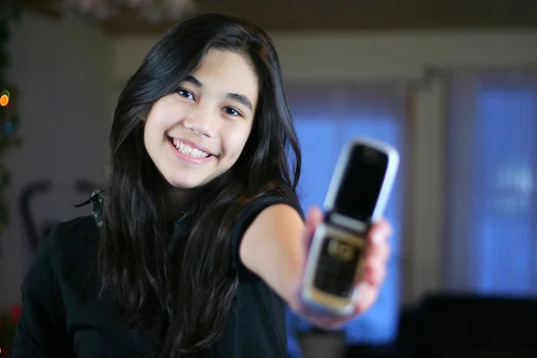 Jovem menina adolescente orgulhosamente segurando seu primeiro telefone celular . — Fotografia de Stock