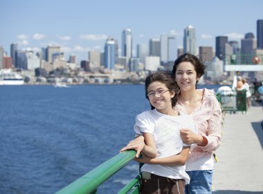 twee zusters op ferry dek met seattle skyline op achtergrond