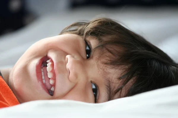 Pequeño niño feliz en su espalda — Foto de Stock