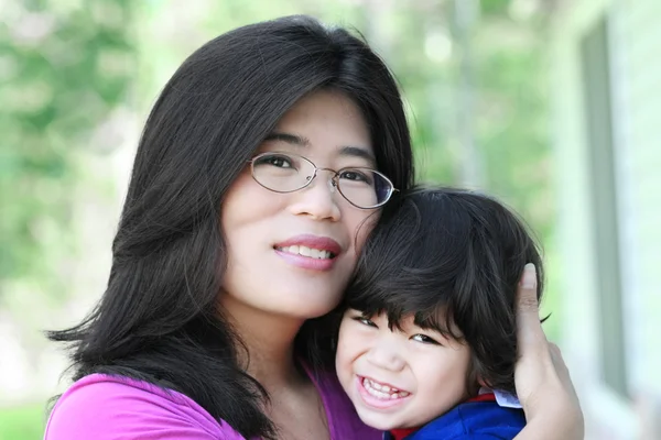 Asian mother lovingly holding her son — Stock Photo, Image