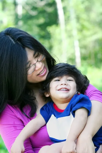 Asiática mãe carinhosamente segurando seu filho — Fotografia de Stock