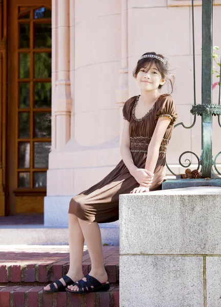 Preteen girl enjoying sunshine on stone steps outdoors — Stock Photo, Image