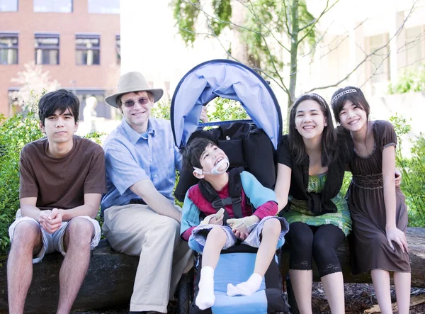 Vader zittend met zijn biracial kinderen en gehandicapte zoon — Stockfoto