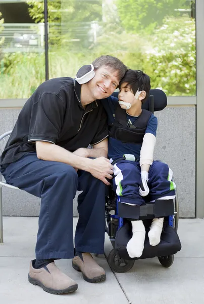 Handicap jongen knuffelen vader terwijl we wachten op ziekenhuis — Stockfoto