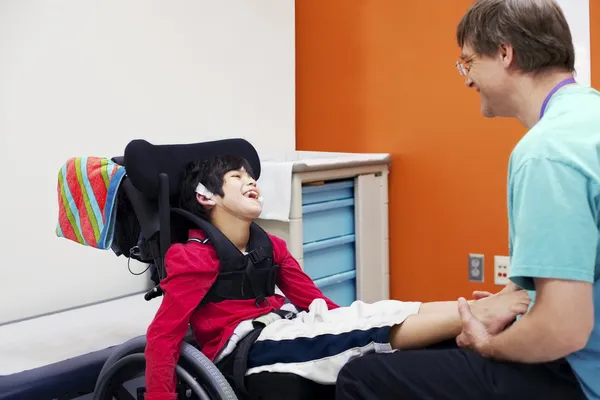 Niño discapacitado en silla de ruedas con su médico — Foto de Stock