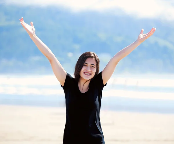 Счастливая молодая женщина на пляже, вытянутые руки — стоковое фото
