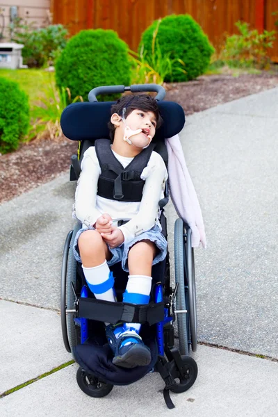 Niño birracial discapacitado de siete años en silla de ruedas — Foto de Stock