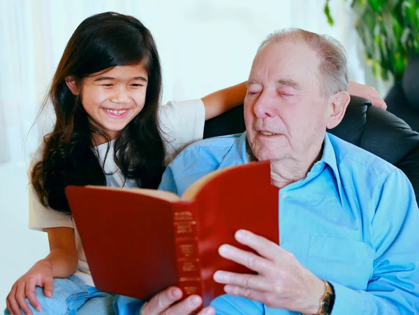 Uomo anziano e bambina leggono insieme la Bibbia — Foto Stock