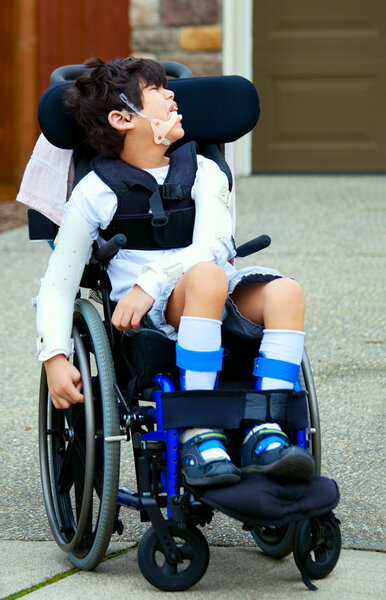 Seven year old biracial disabled boy in wheelchair