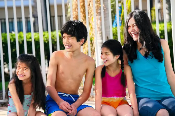 Quatro crianças ao lado da piscina — Fotografia de Stock