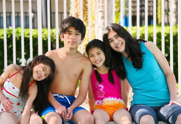 Quatre enfants au bord de la piscine — Photo