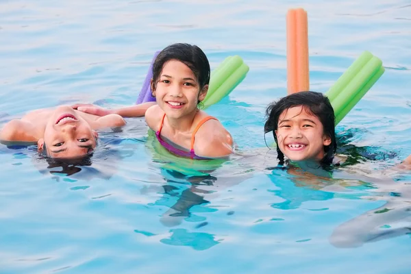 Tres niños divirtiéndose en la piscina — Foto de Stock