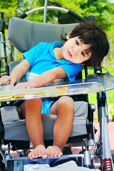 Disabled child in medical stroller