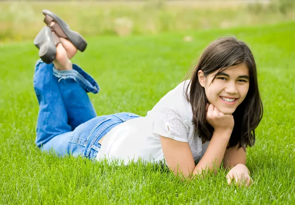 Junges Teenie-Mädchen liegt auf grünem Gras und entspannt sich — Stockfoto