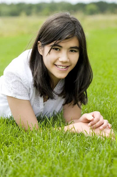 Junges Teenie-Mädchen liegt auf grünem Gras und entspannt sich — Stockfoto